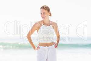 Portrait of pretty woman in white outfit standing on the beach