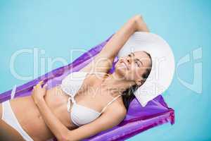 Young woman smiling while relaxing on inflatable raft