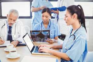 Female doctor using laptop in conference room