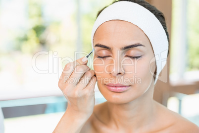 Close-up of woman having eyebrows plucked