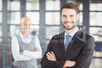 Happy businesman with female colleague in background