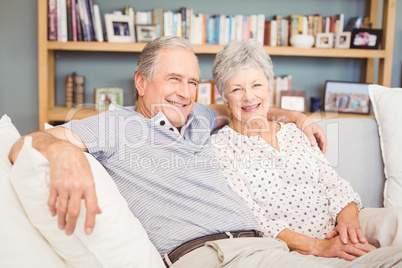 Portrait of happy senior couple sitting on sofa