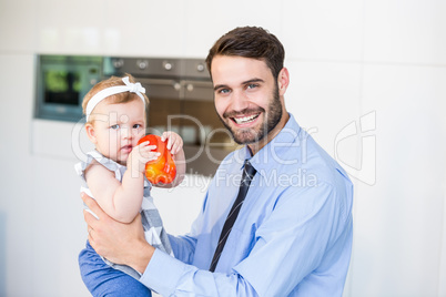 Portrait of happy businessman playing with daughter