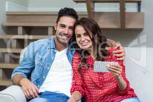 Portrait of smiling couple using smartphone