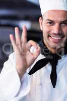 Happy chef making ok sign in commercial kitchen