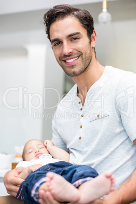 Portrait of smart father carrying baby