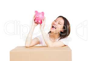 Happy woman holding a piggy bank