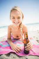 Woman lying on the beach with beer bottle