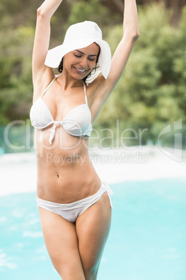 Woman in bikini standing by swimming pool