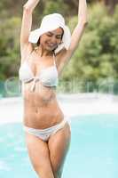 Woman in bikini standing by swimming pool