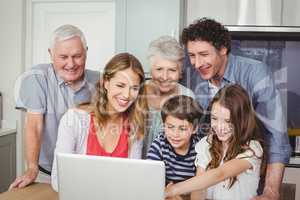 Happy family using laptop in kitchen