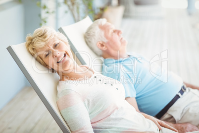 High angle view of senior couple relaxing on lounge chair