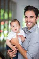 Portrait of cheerful father holding baby