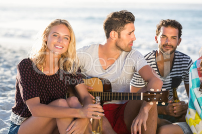 Friends drinking beer and playing guitar