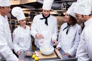 Head chef teaching his team to prepare a dough