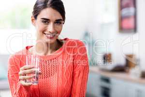 Happy young woman holding drinking glass