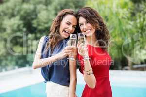 Happy female friends toasting champagne flutes