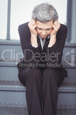 Depressed businesswoman sitting on steps