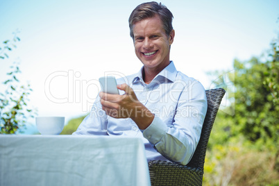 Businessman using smartphone with coffee