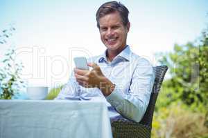 Businessman using smartphone with coffee