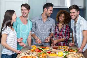 Cheerful multi-ethnic friends preparing pizza at home