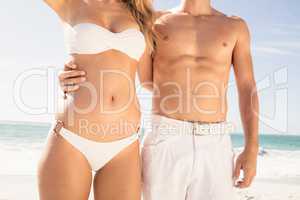 Young couple in beachwear embracing