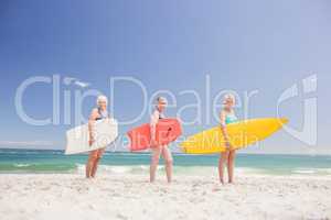 Senior woman friends holding surfboard