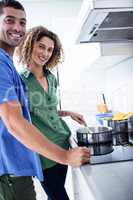 Portrait of couple cooking in kitchen