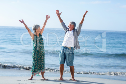 Senior couple raising arms