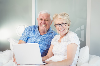 Portrait of happy couple with laptop