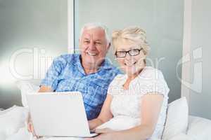 Portrait of happy couple with laptop