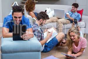 Friends using modern technologies in living room