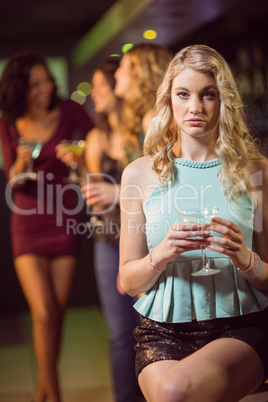 Blonde woman drinking cocktail