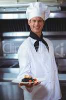 Proud chef holding a plate of squid ink spaghetti