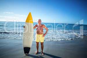 Senior man posing with a surfboard