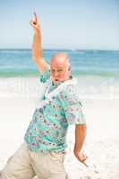 Senior man dancing at the beach