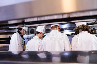 Group of chefs in white uniform busy to preparing food