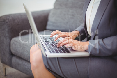 Midsection of bussinesswoman working on laptop