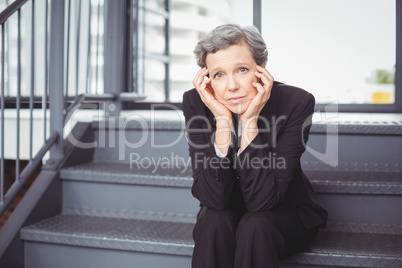 Thoughtful depressed businesswoman sitting on steps