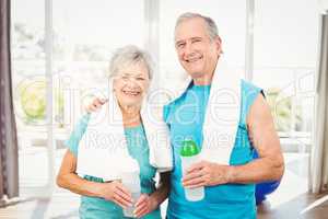 Portrait of smiling senior couple holding bottle