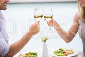 Cropped image of couple toasting white wine