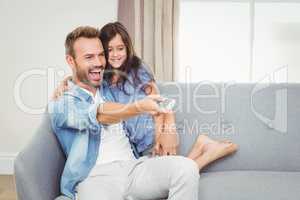 Smiling daughter and father watching television