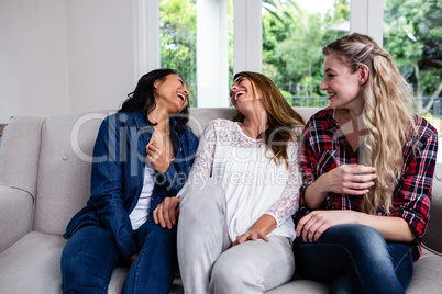 Cheerful female friends sitting on sofa Cheerful female friends sitting on sofa