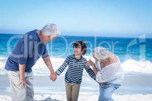 Cute boy holding his grandparents hands