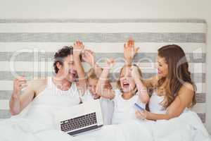 Family enjoying on bed