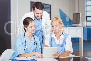 Female doctors using digital tablet while discussing with collea