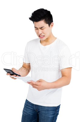 Angry man calculating bills on calculator