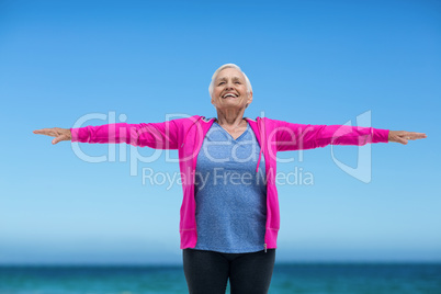 Thoughtful mature woman outstretching her arms