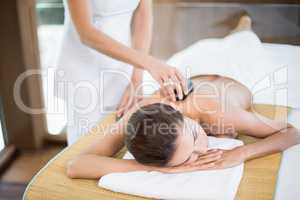 Woman receiving stone massage at spa