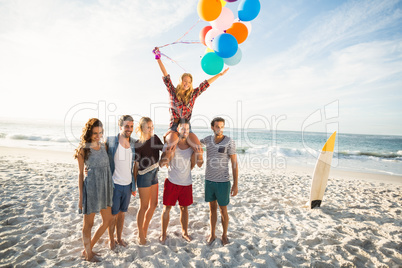 Friends posing with balloon on sand